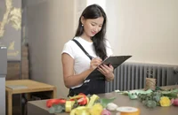 Una empleadora revisando un checklist para incorporar a nuevos empleados.