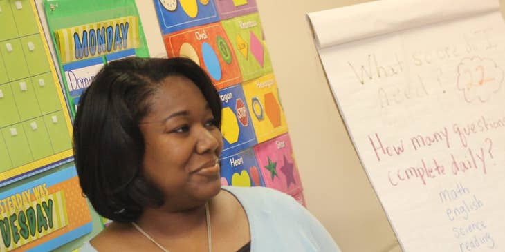Childcare Assistant listens to students while teaching