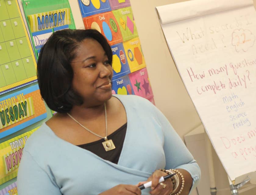 Childcare Assistant listens to students while teaching