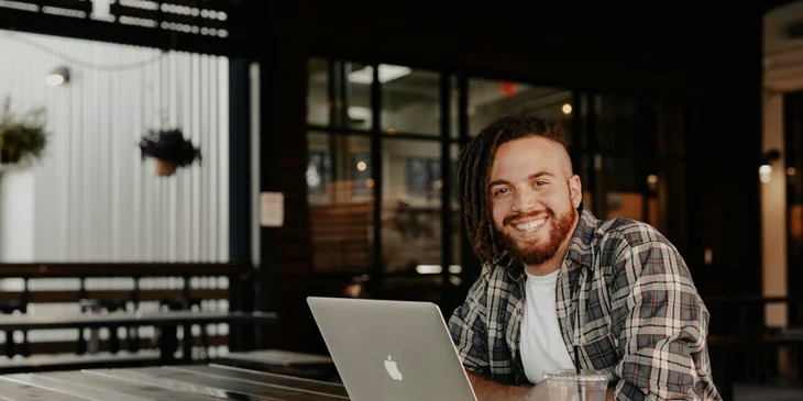 A man happily working while having coffee.