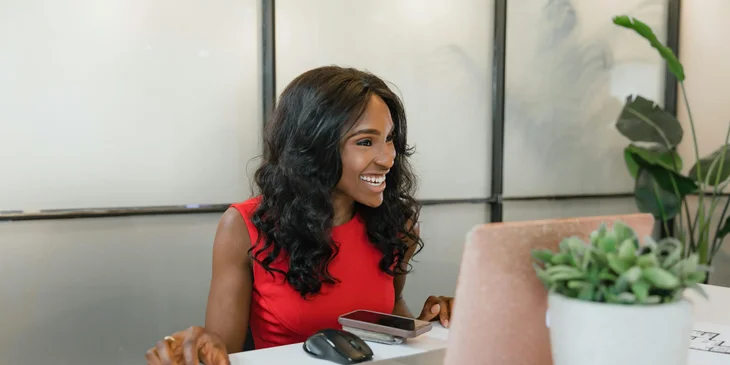 A woman happily working in an office.
