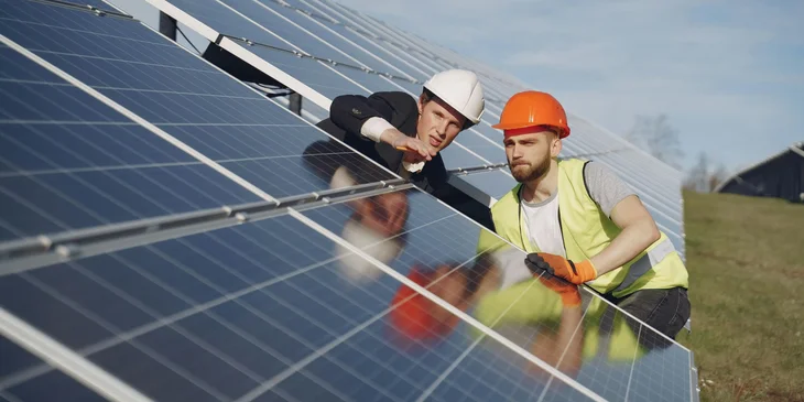 Two electricians inspecting the solar panels.