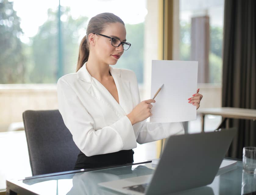 A woman holding a code of ethics document and pointing to it.