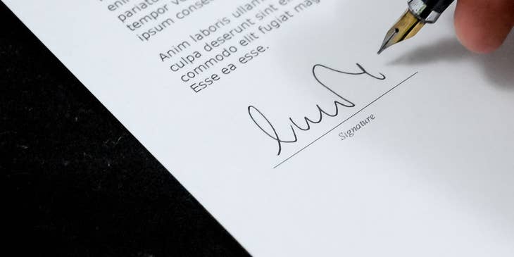 Un hombre firmando una carta de recomendación.