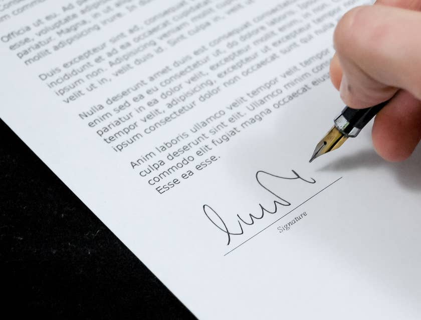 Un hombre firmando una carta de recomendación.