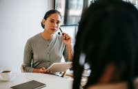 Una donna che fa una domanda a un candidato durante un colloquio.