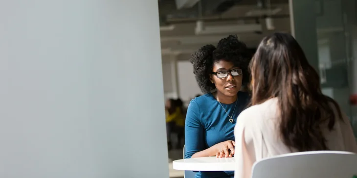 Two women speaking with each other.