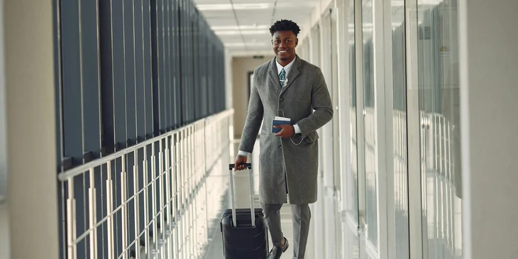 A man carrying luggage in an airport.