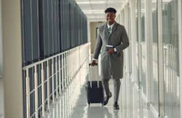 Un hombre con equipaje de ruedas en un aeropuerto.