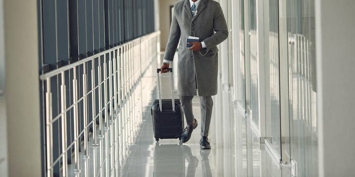 Man in an airport carrying luggage