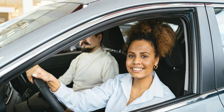 A smiling woman in a company car.