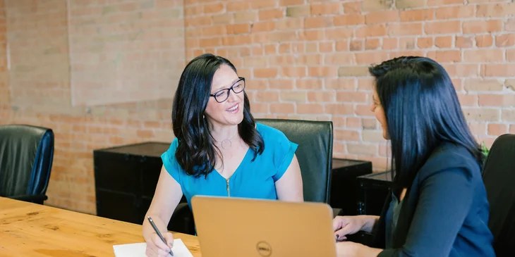 A compensation and benefits manager talking to a coworker.