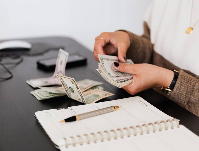 Person counting money and writing notes