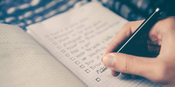 hand making a list in a notebook