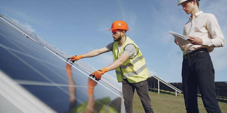 A compliance technician inspecting solar panels.
