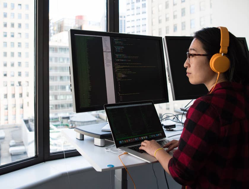 computer programmer working a macbook station