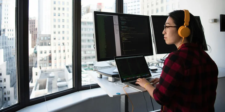 A computer programmer working at a station.