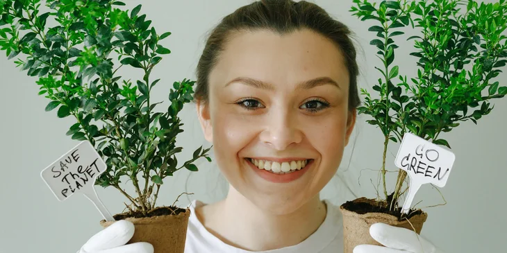 A woman holding a plant in each hand.