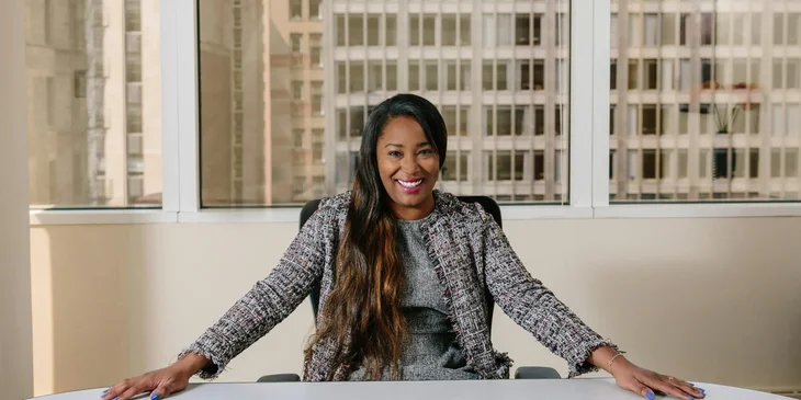 A woman smiling at her desk.