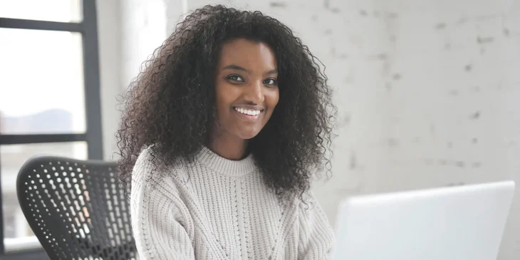 A person smiling at their desk.