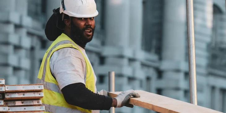 A man in a white helmet working in a construction site.