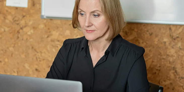 A woman typing on a laptop while sitting.