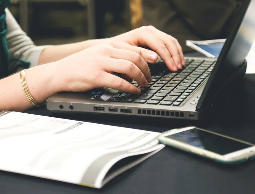 Woman's hands writing a resignation email.