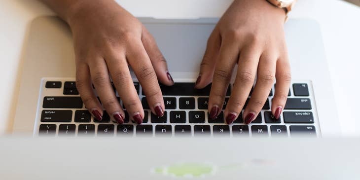 Person typing a cover letter on a laptop.