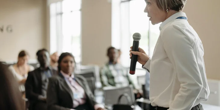 A public relations officer addressing a crowd.