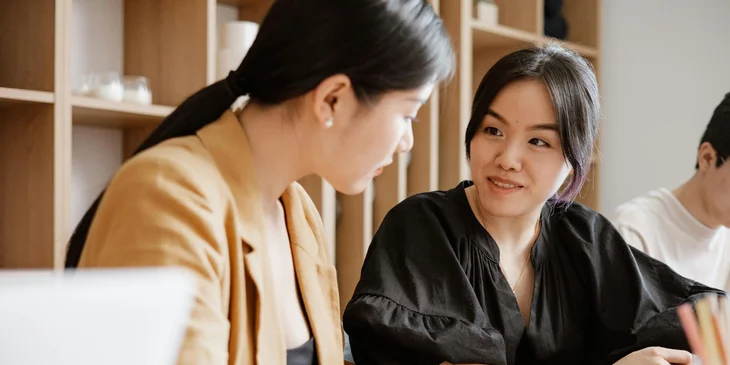 A woman talking with a colleague.