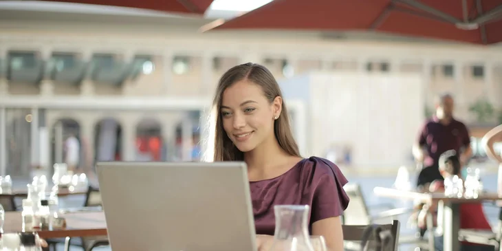 A woman sitting at the table using a laptop.