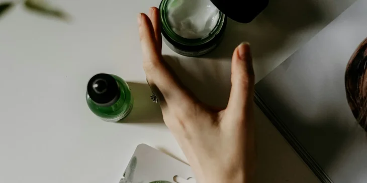 A person reaching for a skincare product ready to be tested.