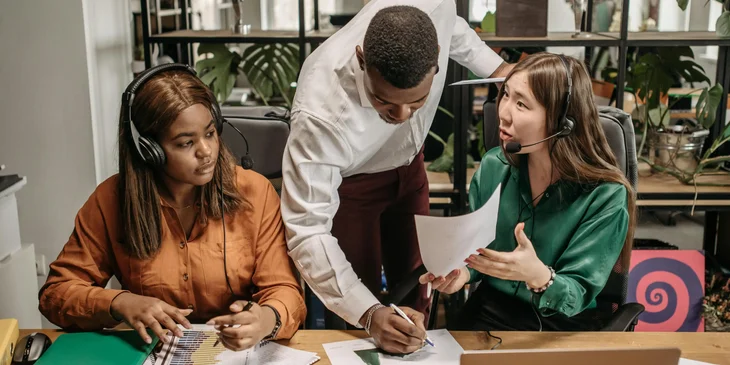 A customer service coordinator assisting his team members.