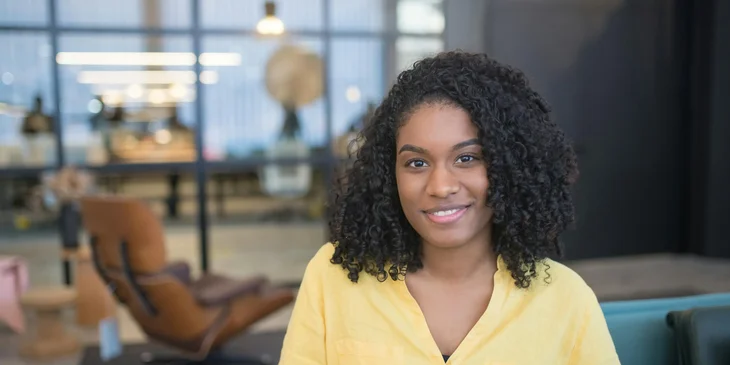 A smiling woman sitting in a conference room.