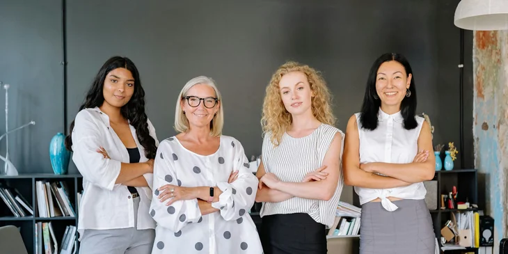 Four colleagues standing with their arms crossed.