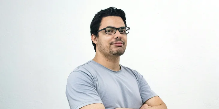 A man crossing both arms and looking at the camera.
