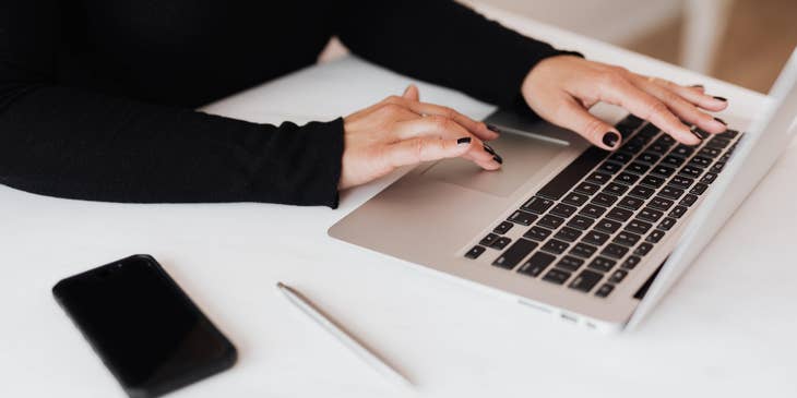 Woman in black top working on a laptop