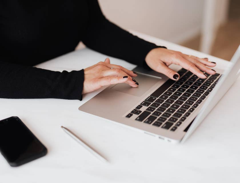 Woman in black top working on a laptop