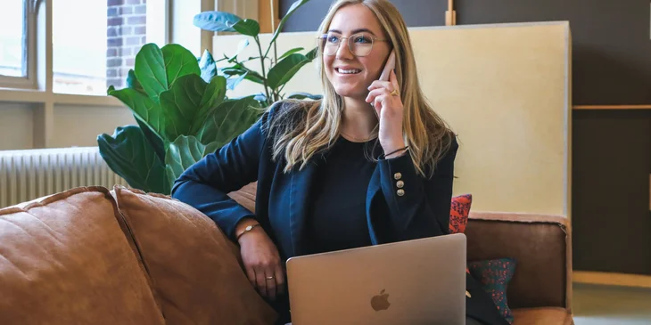 A woman smiling while talking on the phone.
