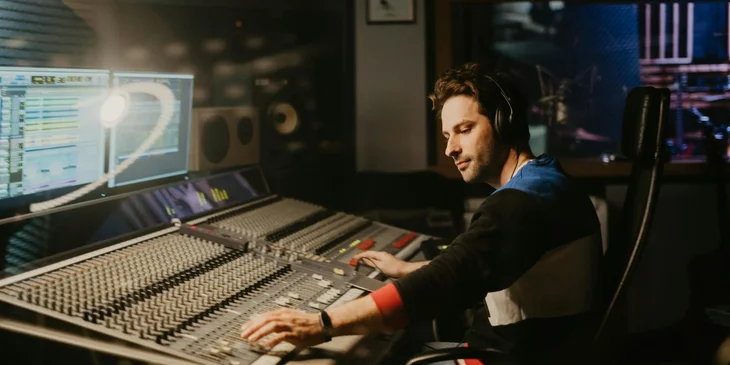 A man adjusting the recording controls at the studio.