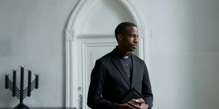 A pastor holding a Bible.