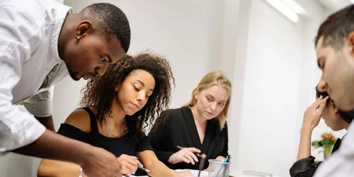 Colegas de trabalho discutindo anotações.