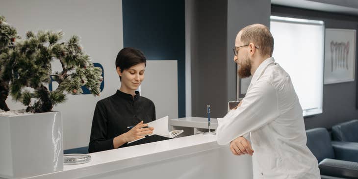 Una recepcionista atendiendo a un cliente en un negocio.