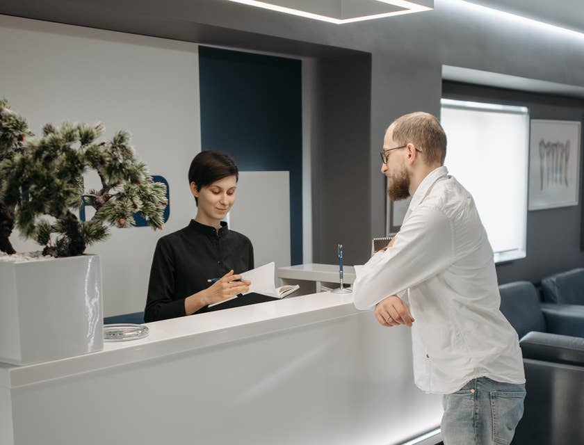 Una recepcionista atendiendo a un cliente en un negocio.