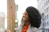 A professional smiling and working on their laptop.