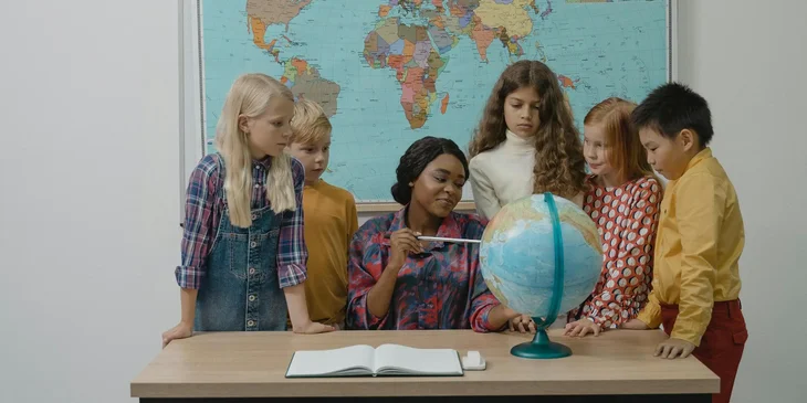 A group of school children listening to a teacher during a lesson.