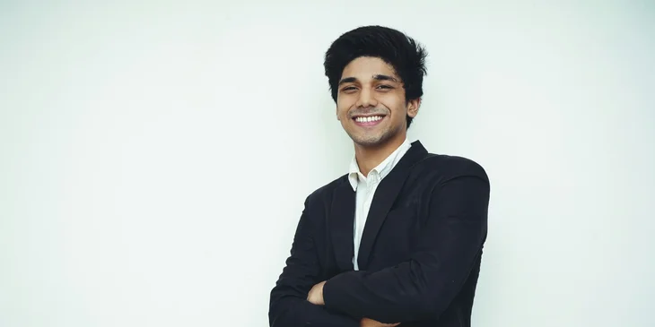 A man posing with a smile, his arms crossed.