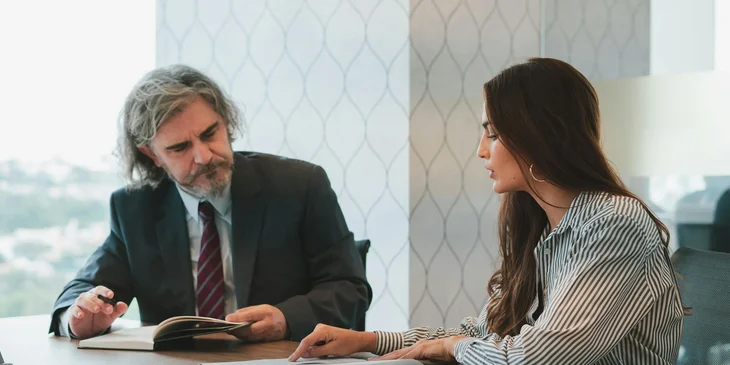 Un empleado de recursos humanos contestándole a un candidato sus preguntas sobre el plan de ahorro 401(k).