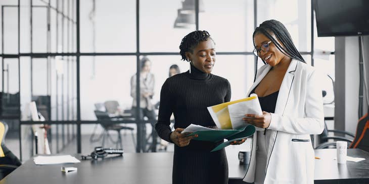 Two office workers discussing employee benefits.