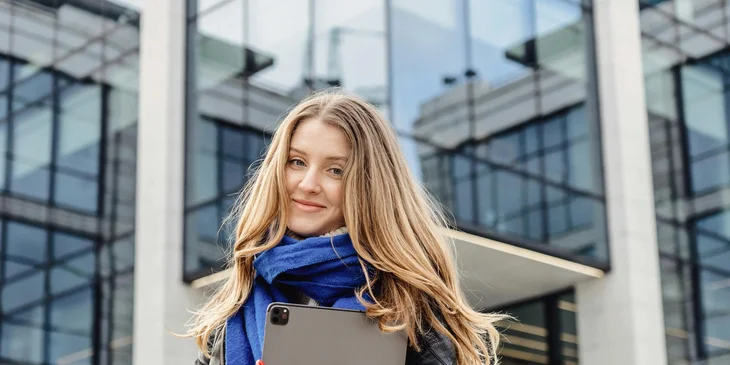 A smiling woman holding a tablet.